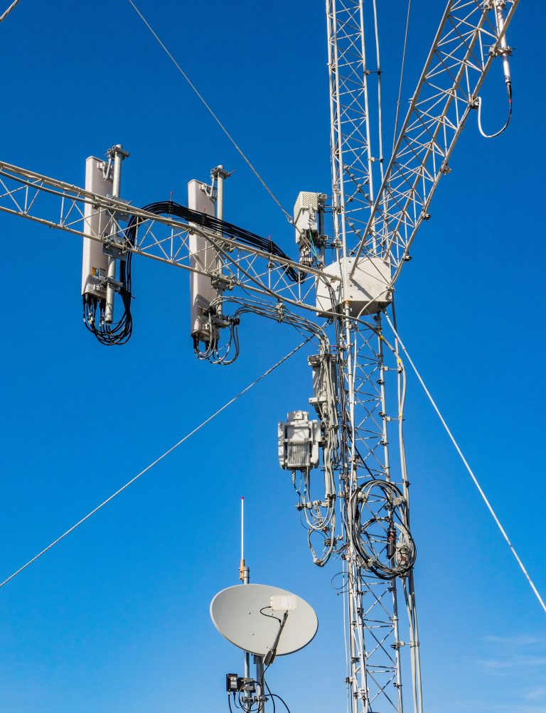 Close-up of a telecommunication tower against a clear blue sky, highlighting modern infrastructure.