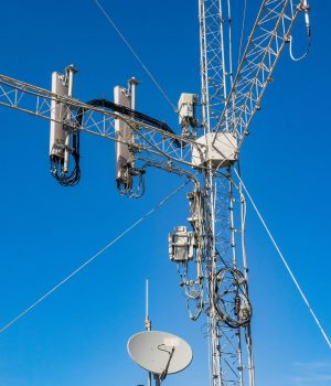 Close-up of a telecommunication tower against a clear blue sky, highlighting modern infrastructure.