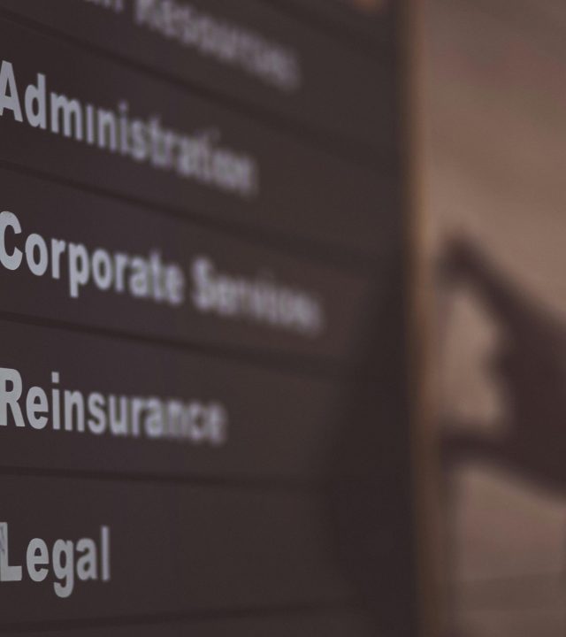 Close-up of an office directory sign showing administration and legal departments.